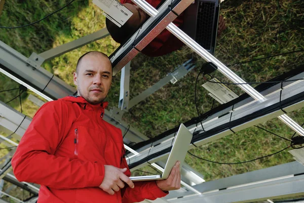 Інженер, який використовує ноутбук на полі сонячних панелей — стокове фото