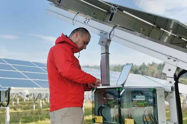 Inżynier korzystający z laptopa w polu elektrociepłowni paneli słonecznych — Zdjęcie stockowe