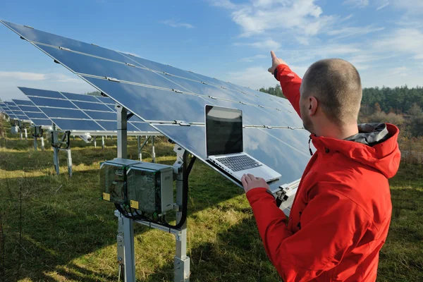 Ingénieur utilisant un ordinateur portable au champ d'usine de panneaux solaires — Photo