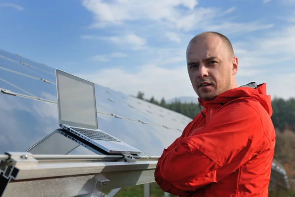 ソーラーパネル工場現場でノートパソコンを使うエンジニア — ストック写真