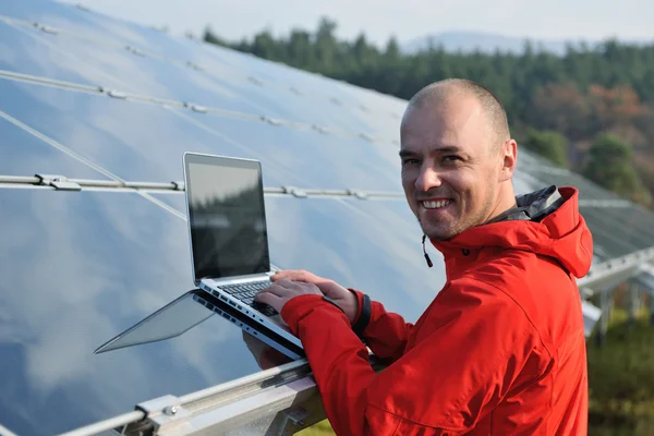 Ingénieur utilisant un ordinateur portable au champ d'usine de panneaux solaires — Photo