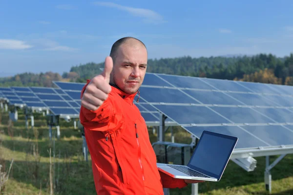 Инженер с помощью ноутбука на солнечных панелях — стоковое фото