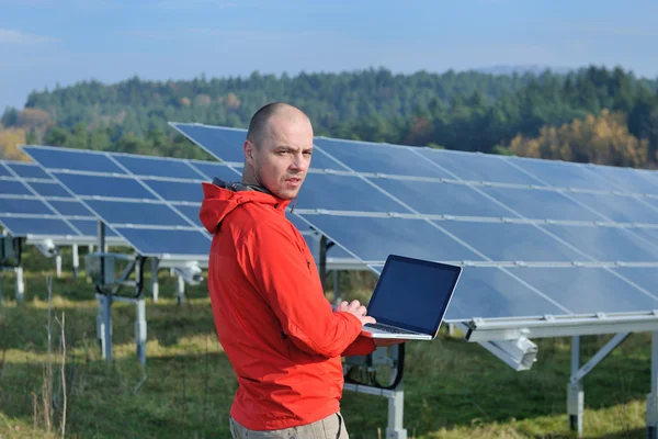 Engineer using laptop at solar panels plant field Royalty Free Stock Photos