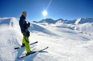 Güzel güneşli bir günde kış mevsiminde taze kar üzerinde kayak yapmak