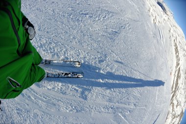 Güzel güneşli bir günde kış mevsiminde taze kar üzerinde kayak yapmak