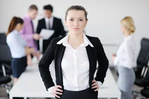 バック グラウンドでの彼女のスタッフで立っている女性実業家 — ストック写真