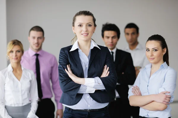 Business woman standing with her staff in background — Stock Photo, Image