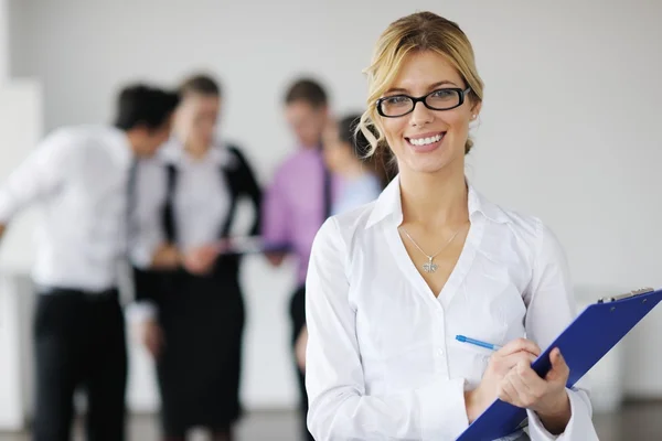 Business woman standing with her staff in background Royalty Free Stock Images