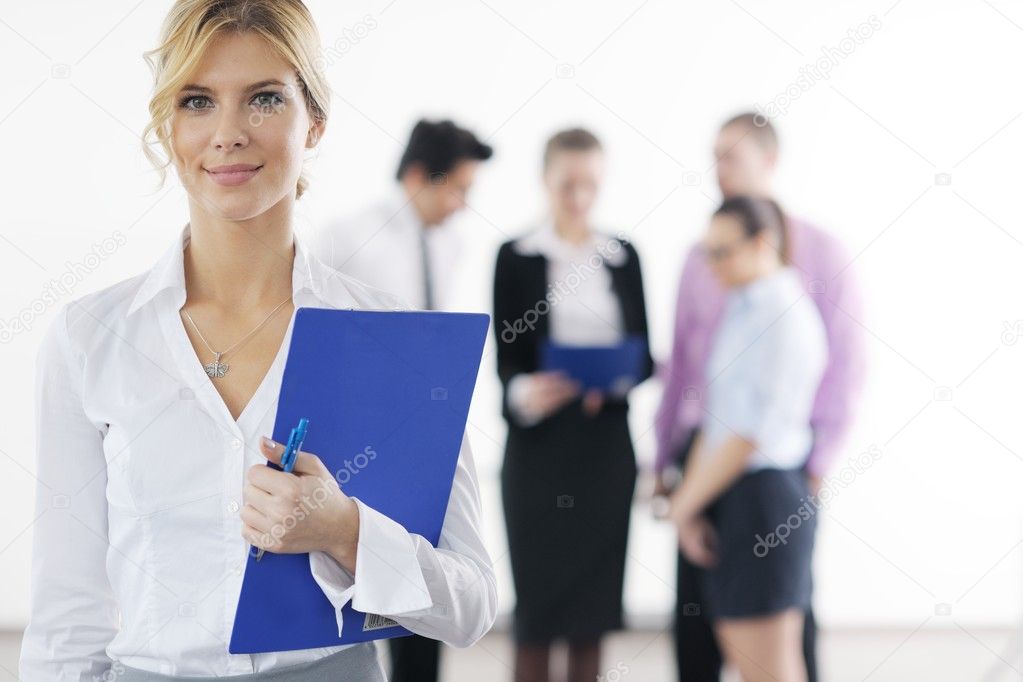 Business woman standing with her staff in background
