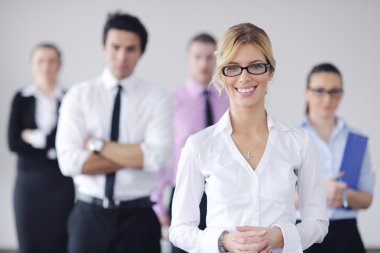 Business woman standing with her staff in background clipart