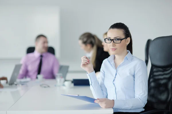 Mujer de negocios de pie con su personal en segundo plano — Foto de Stock