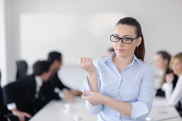 Business woman standing with her staff in background — Stock Photo, Image