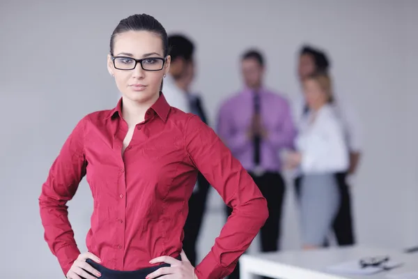 バック グラウンドでの彼女のスタッフで立っている女性実業家 — ストック写真