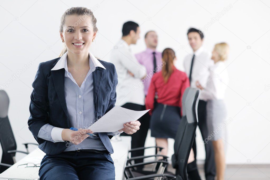Business woman standing with her staff in background