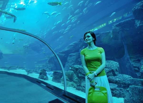 Young woman with big aquarium in backgrond — Stock Photo, Image