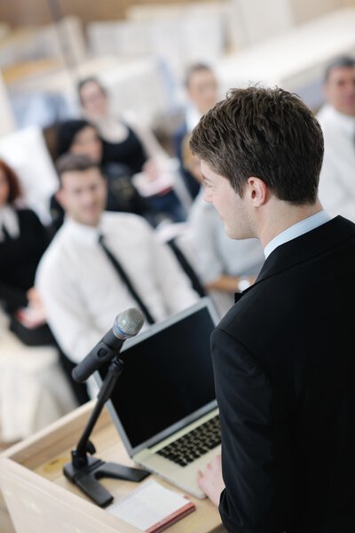 Young business man giving a presentation on conference