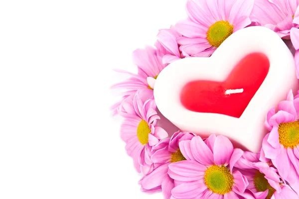 Candle in the shape of a heart and chrysanthemums. — Stock Photo, Image
