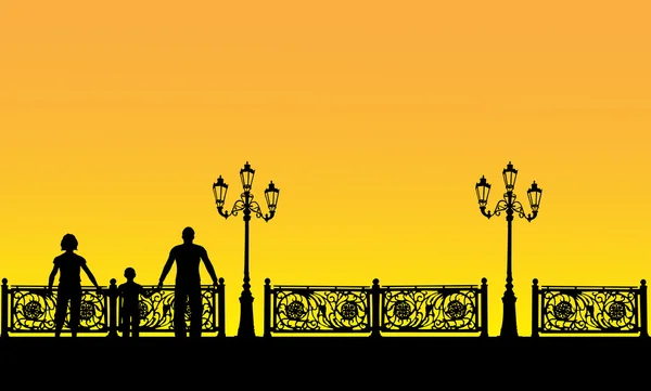 Famille près de clôture au coucher du soleil — Image vectorielle