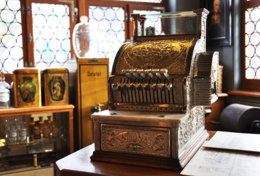 Vintage cash register in an old pharmacy clipart