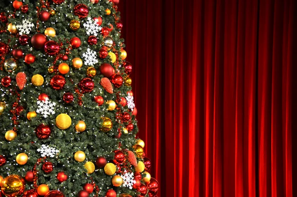 Weihnachtsbaum gegen rote Vorhänge — Stockfoto