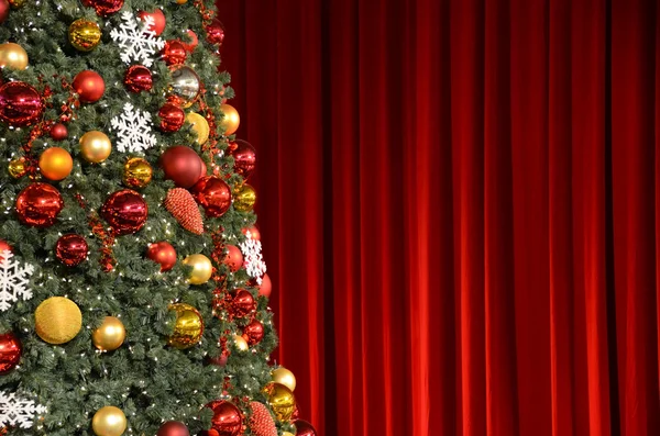赤いカーテンに対するクリスマス ツリー — ストック写真