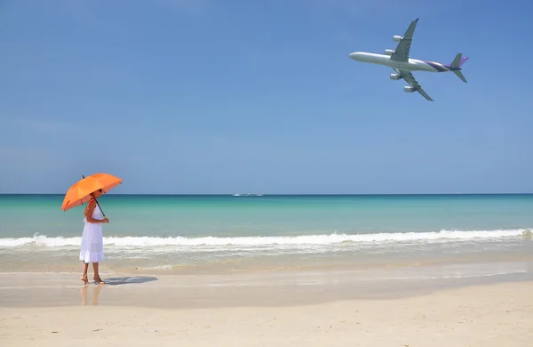 A homokos strandon, egy narancs esernyővel lány — Stock Fotó