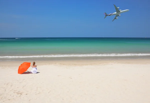 Fille avec un parapluie orange sur la plage de sable — Photo