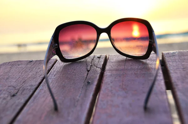Закат океана сквозь солнцезащитные очки — стоковое фото