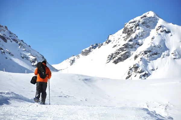 Caminhadas em sapatos de neve ao longo da pista de montanha — Fotografia de Stock