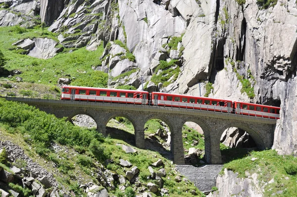 Alpine express passing bridge at St. Gotthard Pass in Switzerlan — Stock Photo, Image
