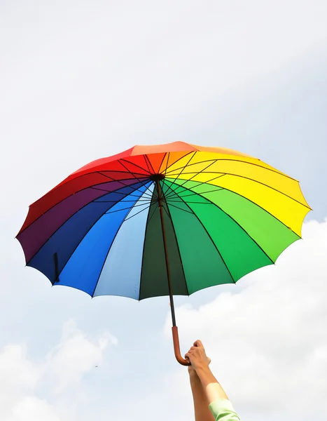 Радужный зонтик в руках — стоковое фото