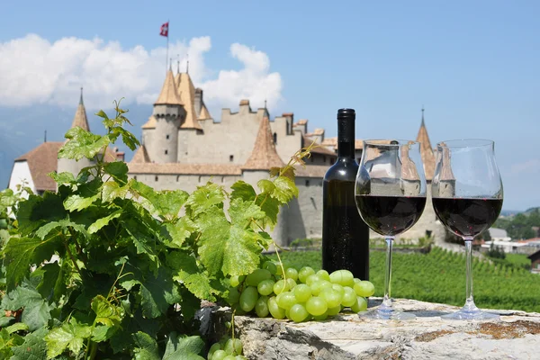 stock image Red wine and grapes against an old castle. Switzerland