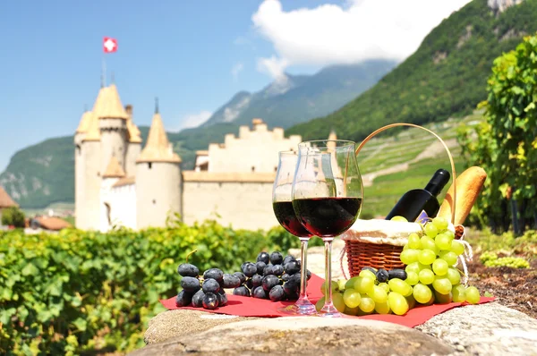 Rött vin och druvor mot ett gammalt slott. Schweiz — Stockfoto