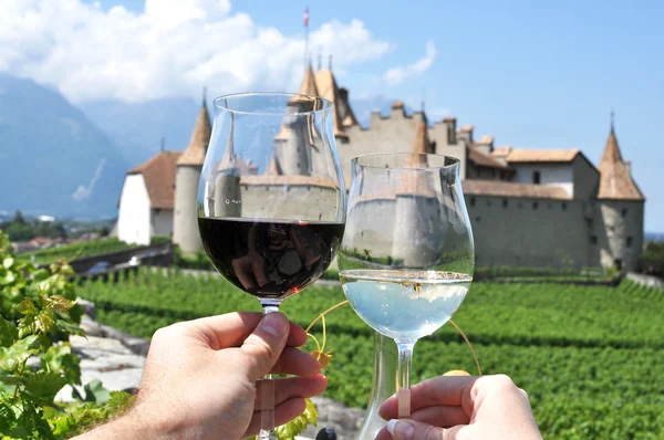 Dos manos sosteniendo las gafas de vino contra Chateau d 'Aigle, Suiza — Foto de Stock