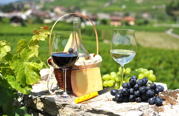 Two wineglasses, grapes and cheese against vineyards. Switzerlan — Stock Photo, Image