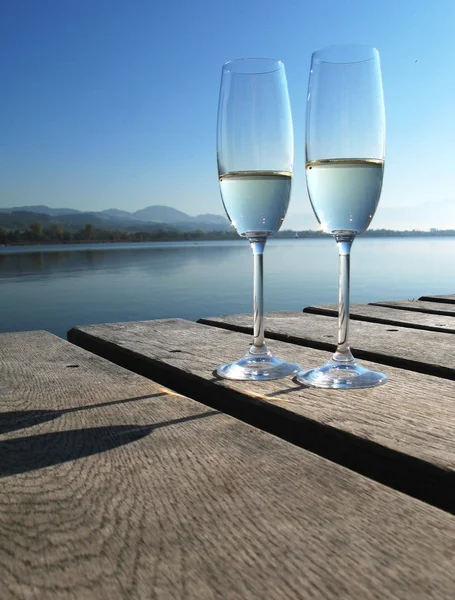 Dois copos de champanhe contra um lago — Fotografia de Stock