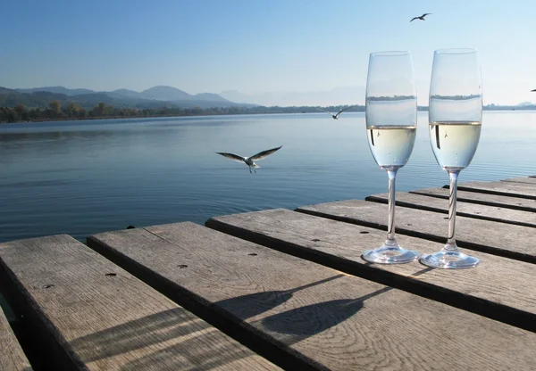 Två champagneglas mot en sjö — Stockfoto