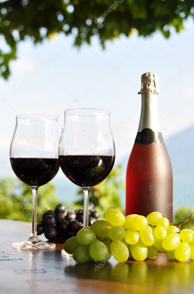 Red wine and grapes against vineyards in Lavaux region, Switzerl