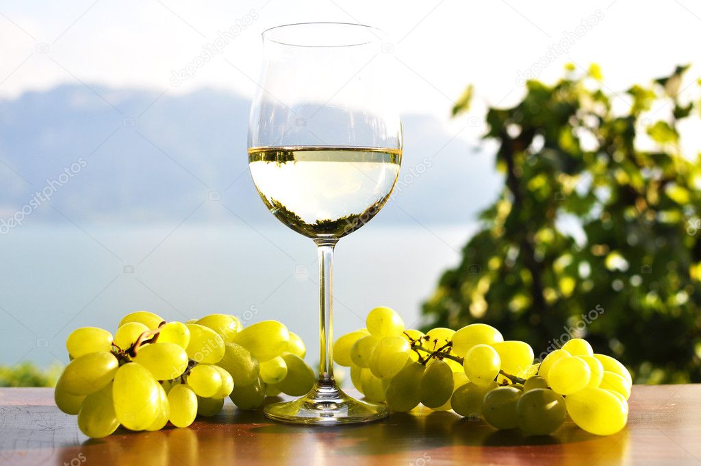 Wineglass and bunch of grapes against Geneva lake. Lavaux region