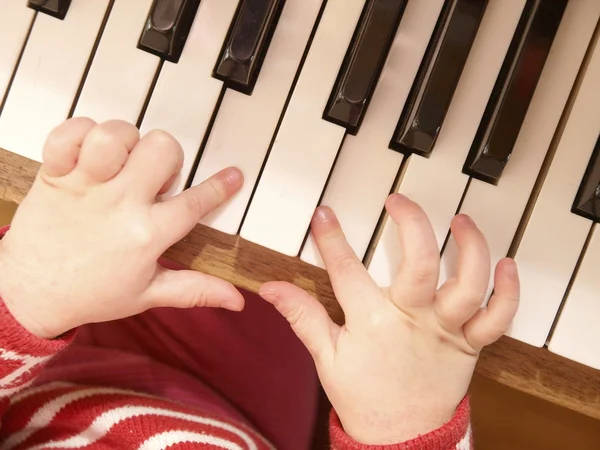 Primer plano de las manos del niño tocando el piano — Foto de Stock