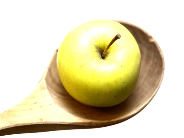 Manzana sobre una cuchara de madera aislada sobre un fondo blanco — Foto de Stock