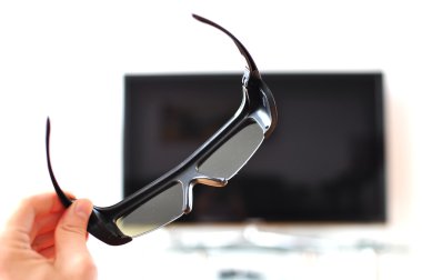 3d-glasses in the hand against TV-set clipart