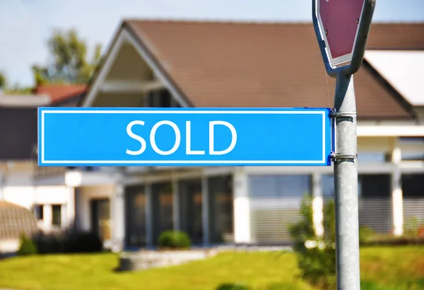 Straatnaambord tegen huis verkocht — Stockfoto