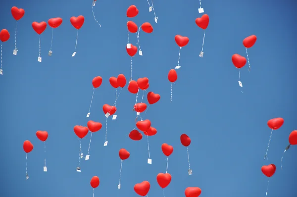 Red ballons with the messages in the blue sky — Stock Photo, Image