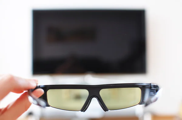 Stock image 3d-glasses in the hand against TV-set