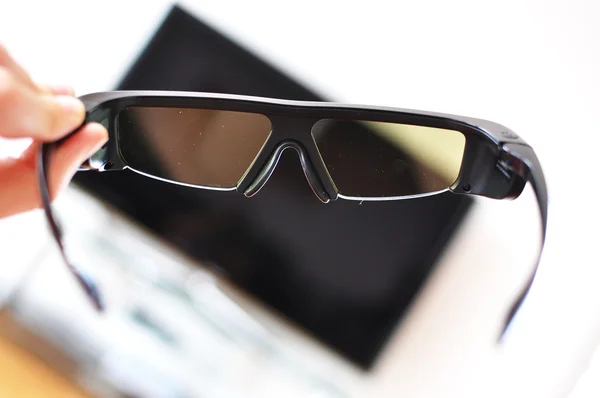 3D-glasögon i handen mot tv-set — Stockfoto