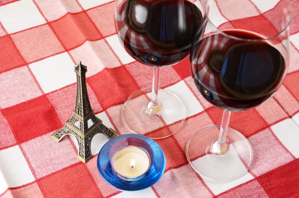 Souvenir Eiffel tower, candle and a pair of wineglasses on the t — Stock Photo, Image