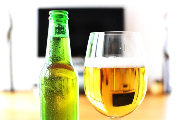 Copo de cerveja contra aparelho de TV — Fotografia de Stock