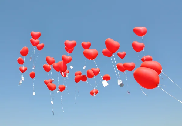 Red ballons with the messages in the blue sky — Stock Photo, Image