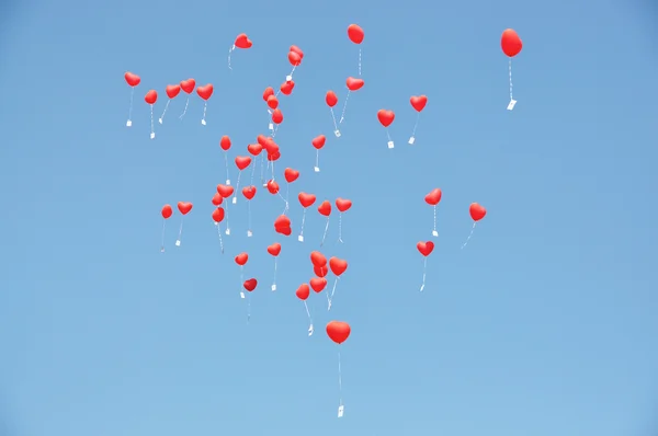 Globos rojos con los mensajes en el cielo azul —  Fotos de Stock